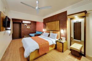 a hotel room with a bed and a couch at Chacha Inn The Garden Retreat in Mount Ābu