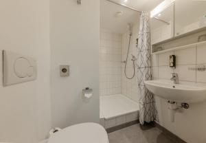 a bathroom with a toilet and a sink and a shower at Villars Lodge in Villars-sur-Ollon