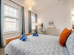 a bedroom with a bed with blue pillows on it at Seagull Escapes - short walk to the beach in Scarborough