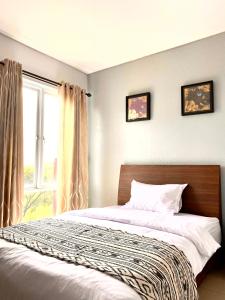 a bedroom with a bed and a window at Behomy Corner 8 Lippo Karawaci in Tangerang