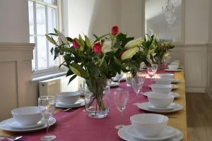 długi stół z talerzami, kieliszkami do wina i kwiatami w obiekcie Brighton Pavilion Gatehouse w Brighton and Hove
