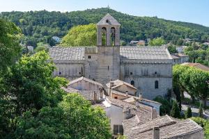 un vieux bâtiment avec une tour et une église dans l'établissement Studio tout confort au Ventoux, à Malaucène