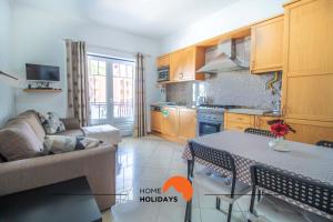 a kitchen with a couch and a table in a room at #101 Kid Friendly with Pool, Private Park, 400 mts Beach in Albufeira