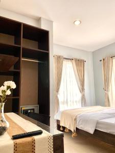 a bedroom with two beds and a window at Behomy Corner 8 Lippo Karawaci in Tangerang