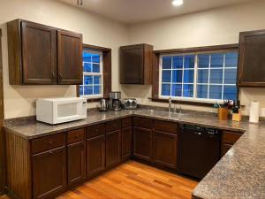 a kitchen with wooden cabinets and a white microwave at Serene Home One Block From Lake Michigan in Sheboygan