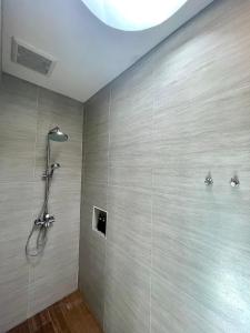 eine Dusche im Bad mit einer Wand in der Unterkunft Villa PaSon in Khao Kho