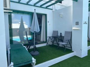 Habitación con mesa, sillas y piscina en Oasis Blue - beautiful 1 bedroom apartment on private complex with pool, en Tías