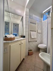 Sofy Squared San Firenze في فلورنسا: حمام أبيض مع حوض ومرحاض