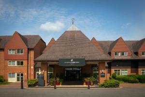 een groot bakstenen gebouw met een puntig dak bij Ashford International Hotel & Spa in Ashford