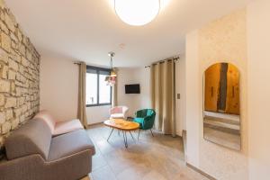 a living room with a couch and a table at Hôtel de la Restonica in Corte