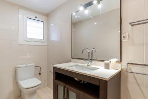 a bathroom with a sink and a toilet and a mirror at AB San Mariano - Park Guell in Barcelona