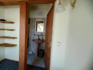 La salle de bains est pourvue d'un lavabo et d'un miroir. dans l'établissement Aušras Mansarde, à Nido