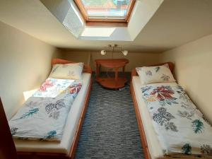 two beds in a small room with a skylight at Aušras Mansarde in Nida