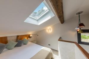 a bedroom with a bed and a skylight at Hôtel de la Restonica in Corte