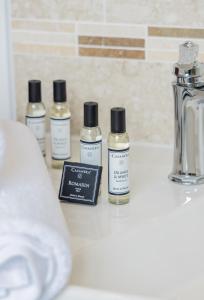 three bottles of essential oils sitting on a bathroom counter at Hôtel de la Restonica in Corte