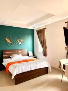a bedroom with a bed and a green wall at Behomy Corner 8 Lippo Karawaci in Tangerang