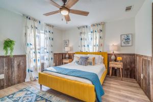 - une chambre avec un lit jaune et un ventilateur de plafond dans l'établissement Modern Lake House with HOT TUB & Gameroom, à Wylie