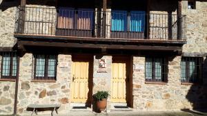 um edifício com portas amarelas e uma varanda em Aguamarina SPA Azagalla Rural em Casas del Abad