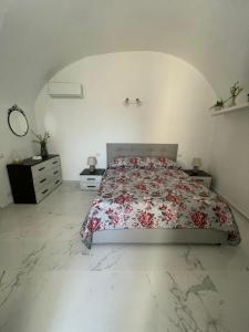 1 Schlafzimmer mit einem Bett mit Blumendecke in der Unterkunft Borgo del Sole in Foglianise