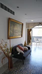 a living room with a couch and a painting on the wall at riad casa bahia asilah in Asilah