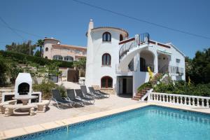 a villa with a swimming pool and a house at BVMorales - stunning sea view villa in Benissa in Benissa