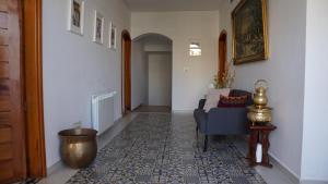 a living room with a blue chair and a rug at riad casa bahia asilah in Asilah