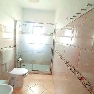 W łazience znajduje się toaleta i przeszklony prysznic. w obiekcie Casa Rocha Relax w Aljezur