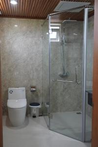 a bathroom with a glass shower with a toilet at Thiên Ân Hotel in Thôn Dương Phẩm