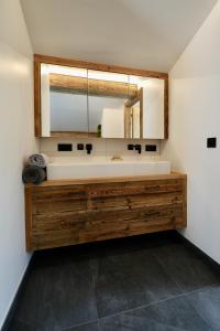 uma casa de banho com um lavatório e um espelho grande em Lakeside Penthouse 16 by we rent em Zell am See