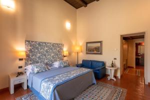1 dormitorio con 1 cama y 1 sofá azul en Maison Tofani, en Sorrento