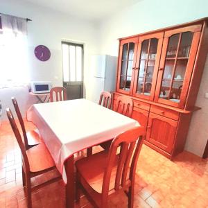 La cuisine est équipée d'une table, de chaises et d'un réfrigérateur. dans l'établissement Casa Rocha Relax, à Aljezur