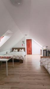 a white bedroom with a bed and a red door at HOKE lakás in Sopron