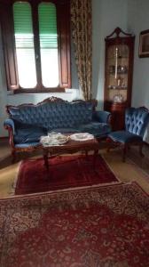 sala de estar con sofá azul y alfombra roja en Villa Le Palme in Tuscany, en Lari