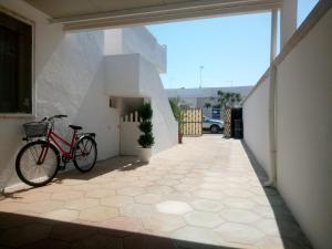 a red bike parked on the side of a building at La Torre Apartment by My Home Apulia in Torre Lapillo