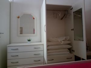 a bathroom with a white dresser and a mirror at La Torre Apartment by My Home Apulia in Torre Lapillo +32 photos