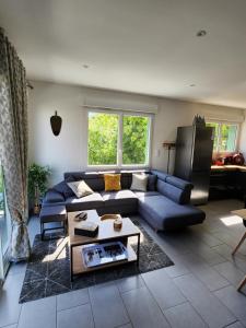 Appartement vue mer في سان-جورج-دي-ديدون: غرفة معيشة مع أريكة زرقاء وطاولة
