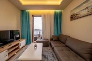 a living room with a couch and a television at Mar Azul Apartments Petrovac in Petrovac na Moru