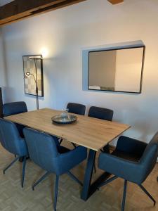 einen Esstisch mit blauen Stühlen und einem Spiegel in der Unterkunft Charming 3 Bedroom Duplex 