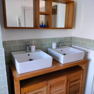 une salle de bain avec deux lavabos blancs et un miroir dans l'établissement Gîte privatif, proche nature et plan d'eau, à Charlanges 17 autres photos