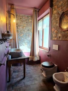 ein Bad mit einem WC, einem Waschbecken und einem Fenster in der Unterkunft Il Pievano B&B in Campiglia Marittima