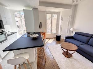 een keuken en een woonkamer met een blauwe bank bij 1 bedroom Palais Hoche Cannes 5 mins from the Croisette Cannes Riviera 226 in Cannes