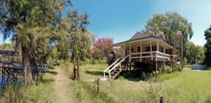 una casa en medio de un campo con árboles en Lodge isleño Monte Blanco en Tigre