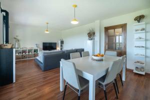 a kitchen and living room with a white table and chairs at Casa vacacional Ris in Duyos