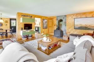 a living room with a couch and a table at Gorgeous Sunday River Cabin with Saltwater Hot Tub! in Newry