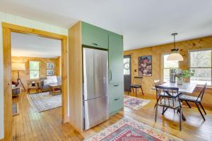 a kitchen and dining room with a refrigerator and a table at Gorgeous Sunday River Cabin with Saltwater Hot Tub! in Newry