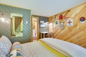 a bedroom with a bed and a wooden wall at Gorgeous Sunday River Cabin with Saltwater Hot Tub! in Newry