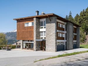 a large brick building with a wooden roof at Chez Elsy - Crans-Sapins in Crans-Montana