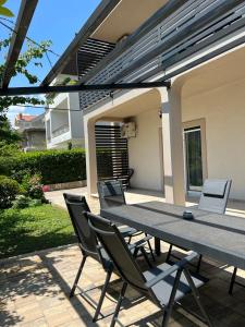 a picnic table and chairs in front of a house at Gemini Apartments in Kaštela