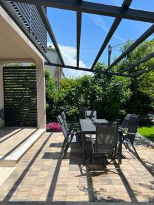 a dining table and chairs on a patio at Gemini Apartments in Kaštela