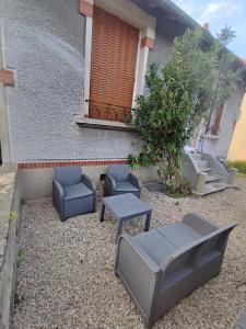 a patio with chairs and tables in front of a building at Petite maison avec jardin in Montluçon